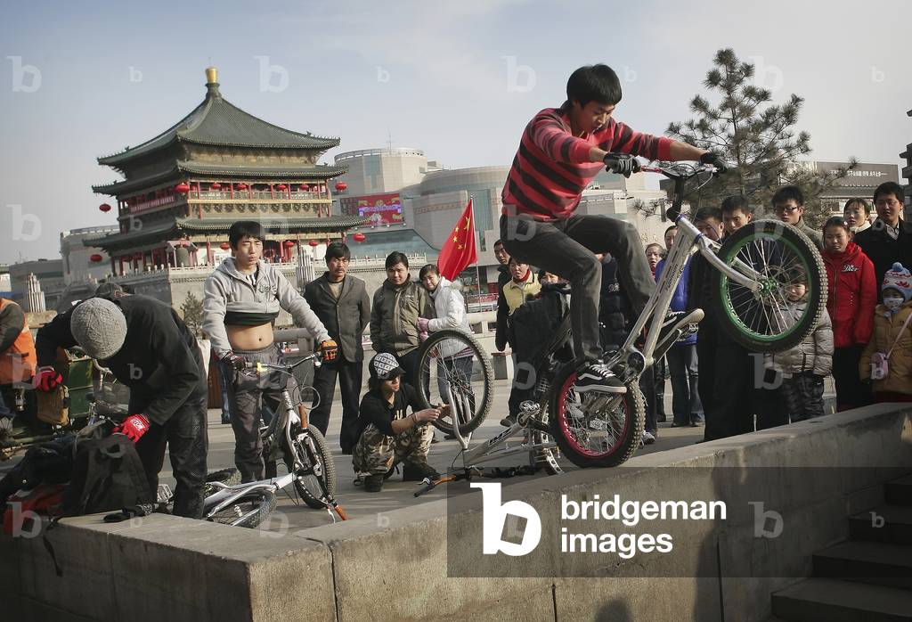 Chinese Youths Riding Mountain Bikes Near An Ancient Bell Tower, Xian, Xi'an, Capital of Shaanxi Province, China (photo)