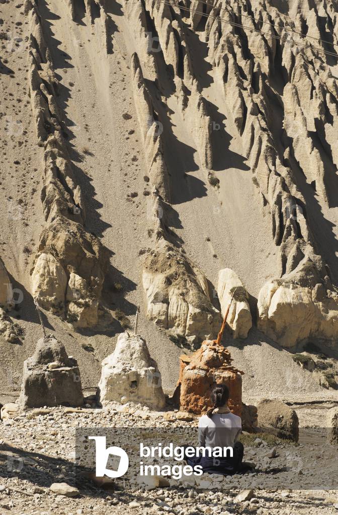 Woman Meditating in Front of Chortens (Stupas), Tangbe, Upper Mustang Valley, Nepal (photo)