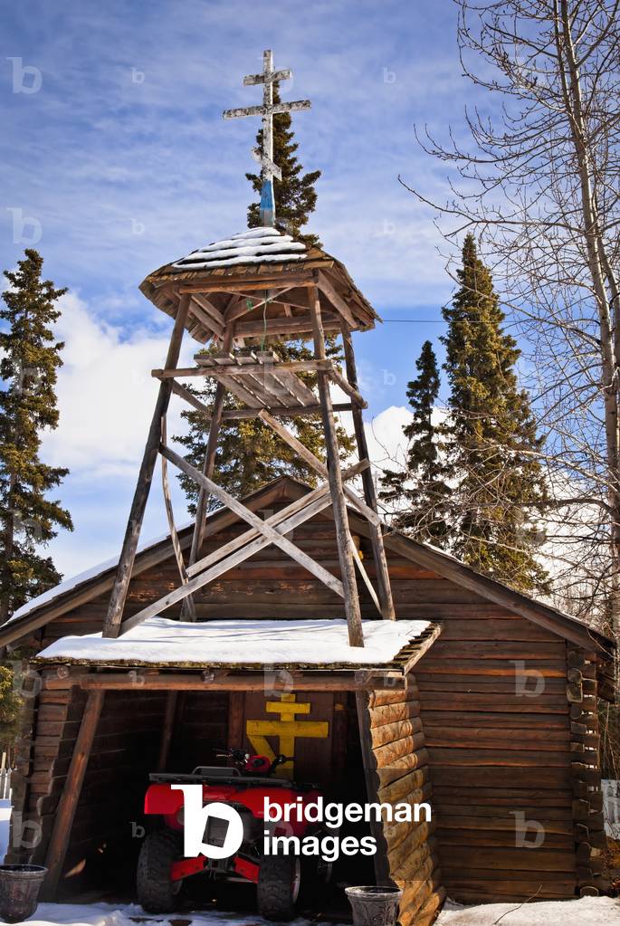 Log building of Old Saint Nicholas Church with an ATV parked under the entrance, Eklutna Village Historical Park, Southcentral, Alaska, Winter (photo)