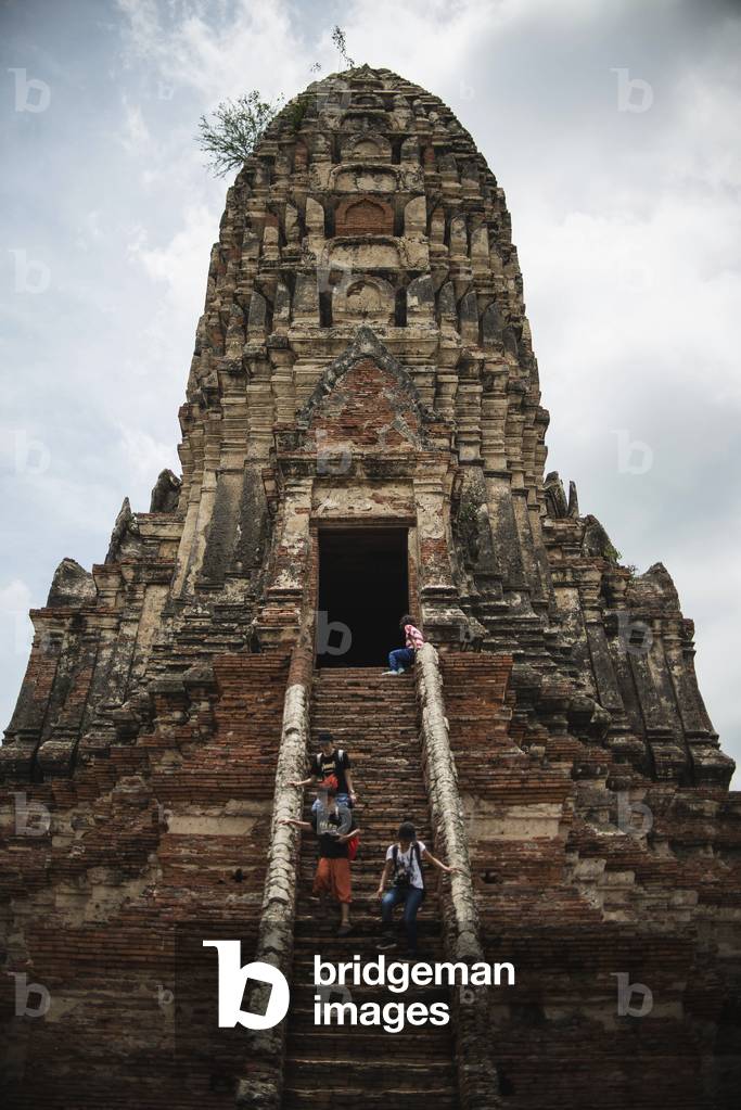 Tourists descend the steps of a ruined temple in the ancient city of Ayutthaya in central Thailand, Ayutthaya, Thailand (photo)