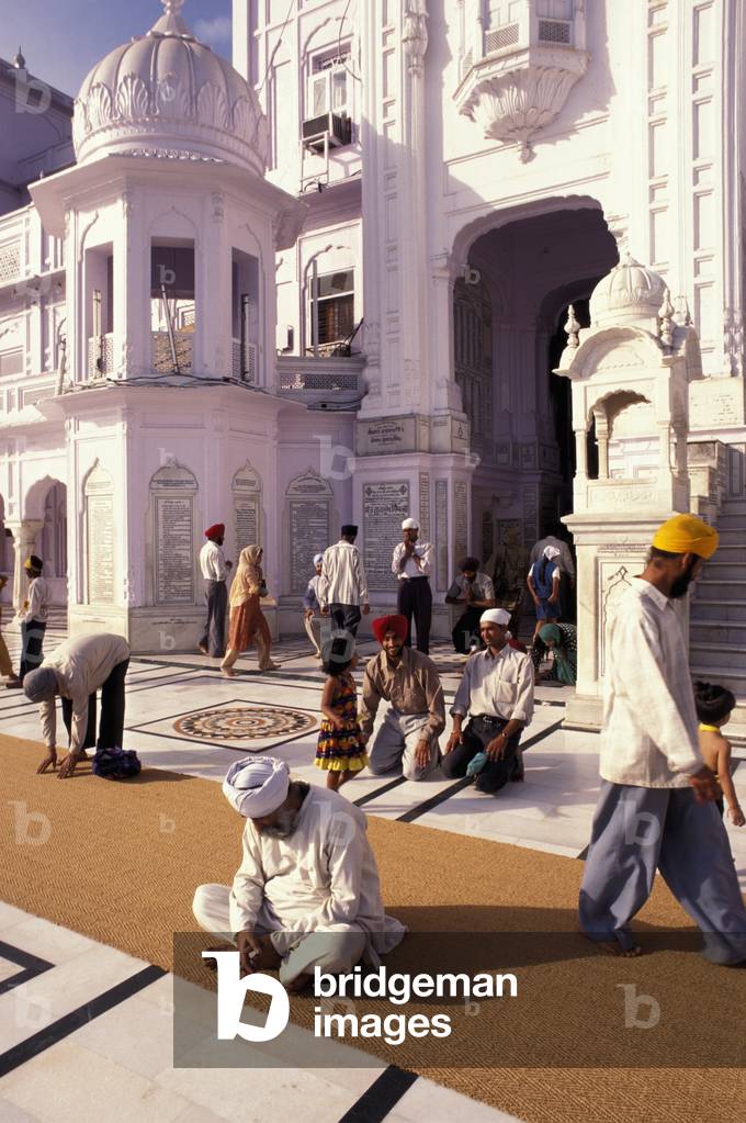 Man Sitting on Rug with People Behind, Golden Temple, Amritar, Punjab, India (photo)