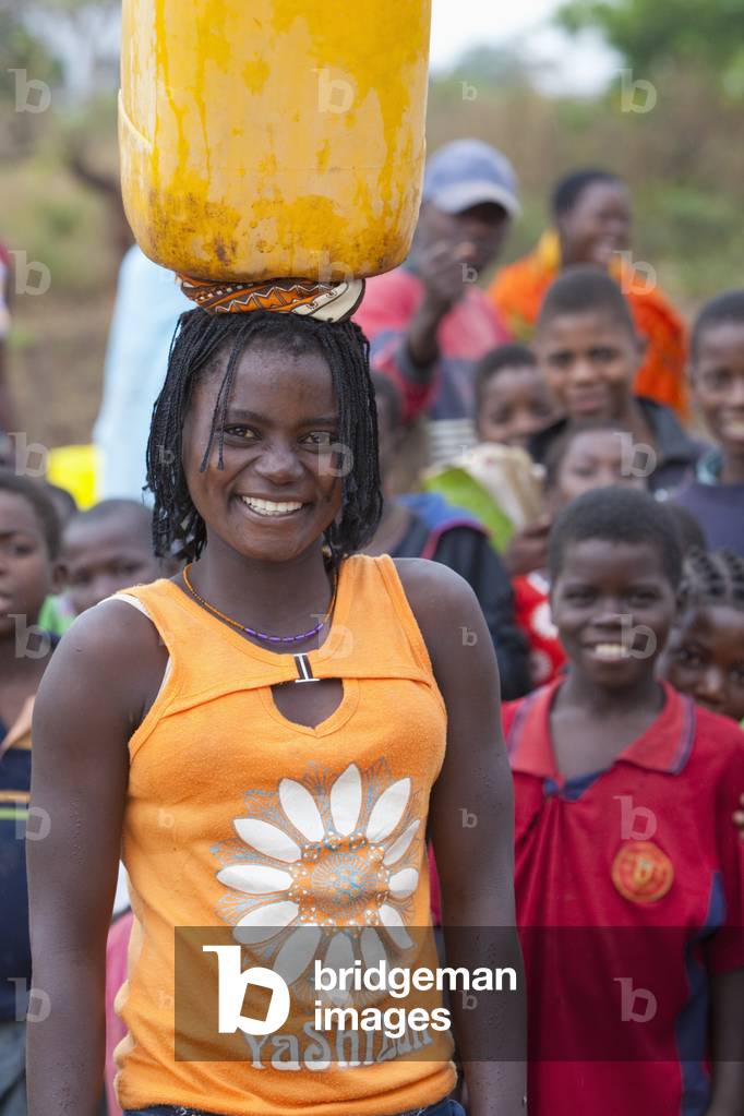 A Young Woman Balances a Water Jug on her Head, Manica, Mozambique, Africa (photo)