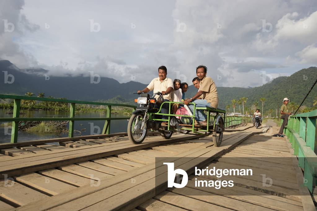 Motorbike tricycle taxi crossing a temporary bridge, after the Indian Ocean tsunami in 2004, Lamno, Sumatra, Indonesia (photo)