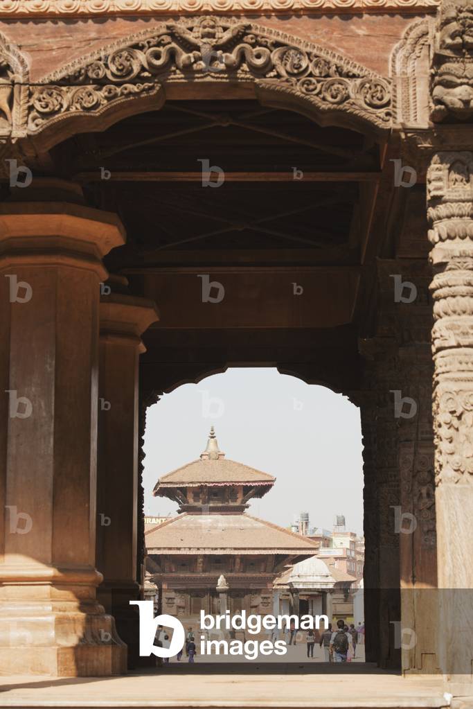 A view through collosal carved arches towards the Gopi Nath Temple in Bhaktapur Durbar Square, Bhaktapur, Nepal (photo)