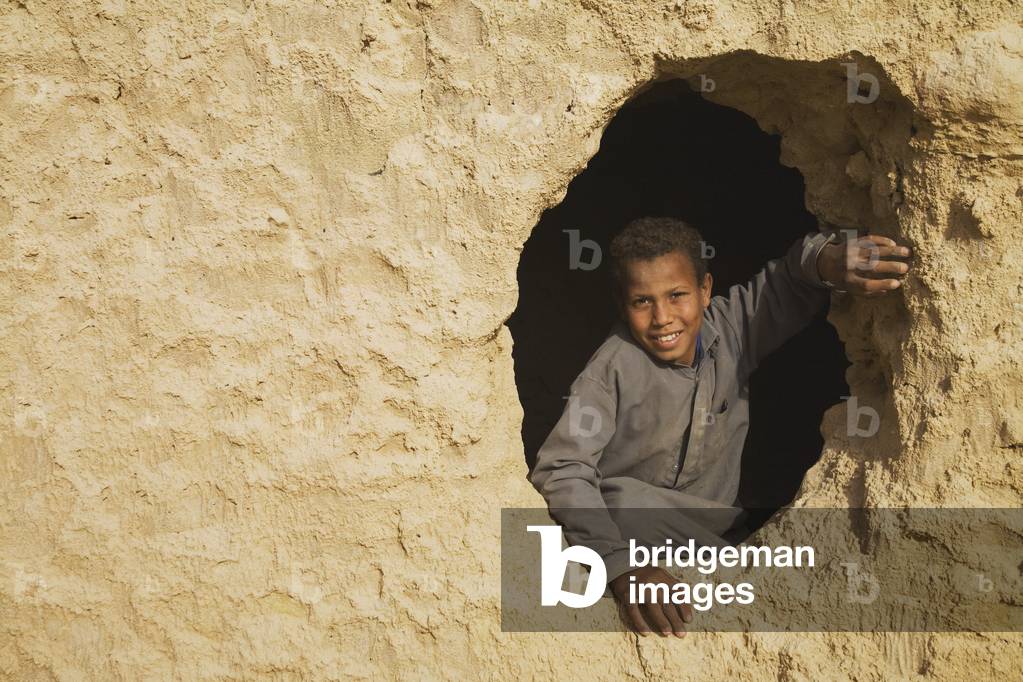 A Smiling Berber Boy looking out from the Fortress of Shali in Siwa, Egypt (photo)