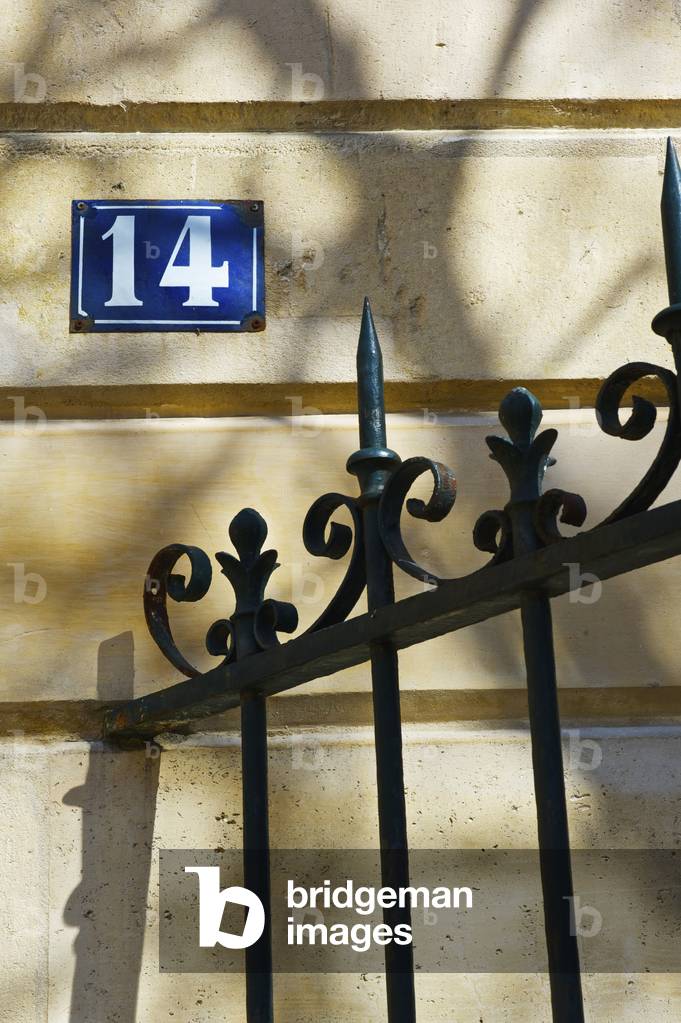 Number fourteen sign and an ornate railing against a building, Marais district, Paris, France (photo)