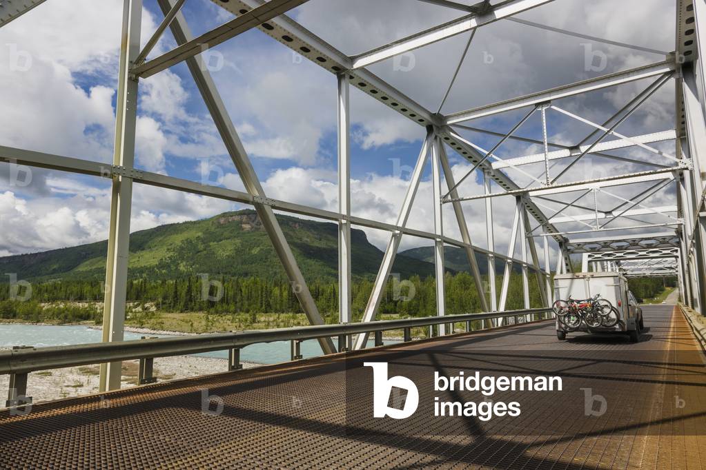 Car and trailer crossing a metal bridge over the Racing River, Alaska Highway, West of Fort Nelson, British Columbia, Canada, Summer (photo)