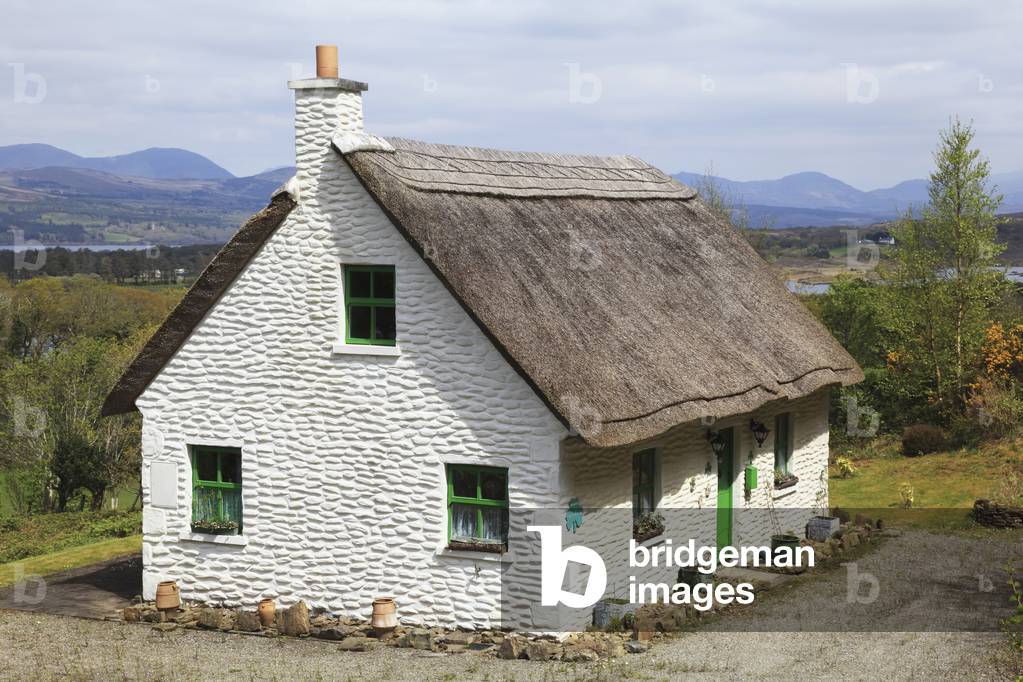 A white house with green door and trim and a thatched roof; Tuosist, County Kerry, Ireland (photo)