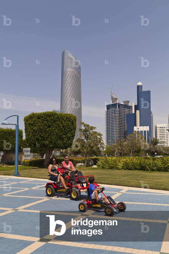 People with pedal cars on Abu Dhabi Corniche, Abu Dhabi, United Arab Emirates (photo)