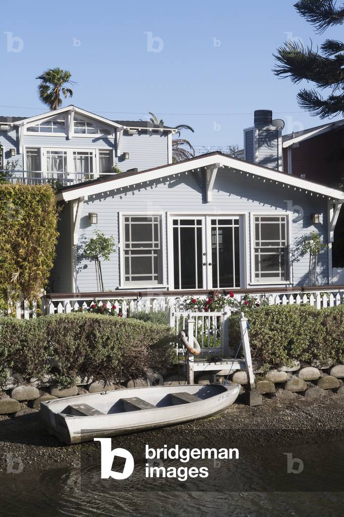 A house along the water with a canoe on the rocky shore, California, USA (photo)