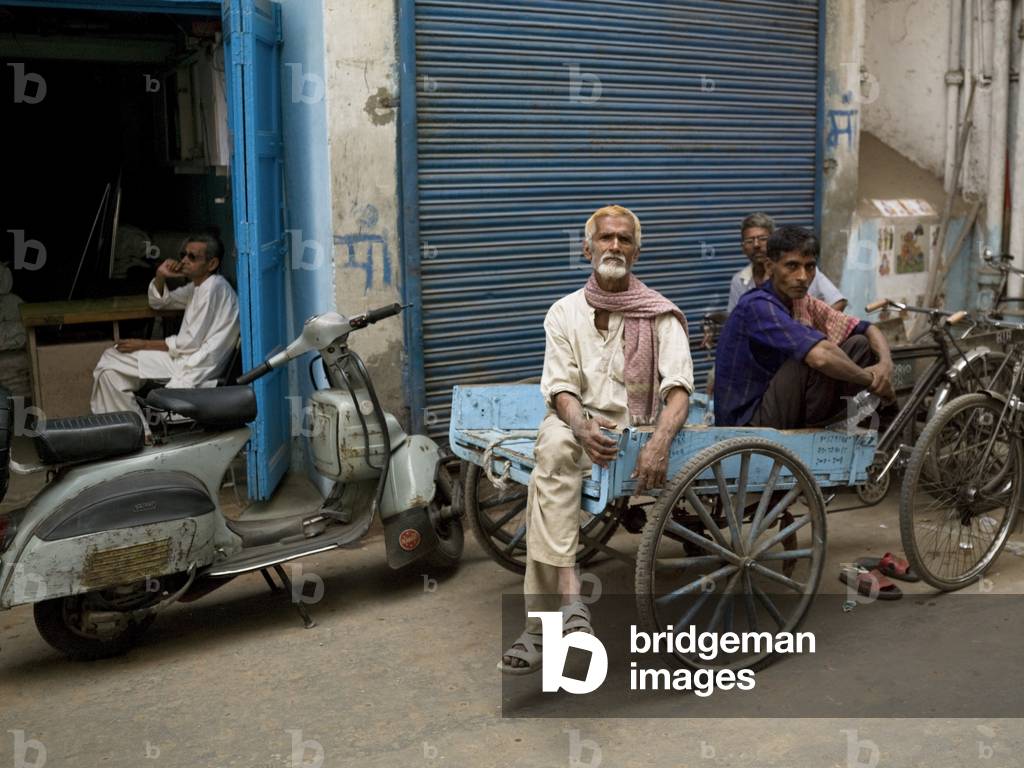 Men sitting on a Cart outside Shop Front, Delhi, India (photo)