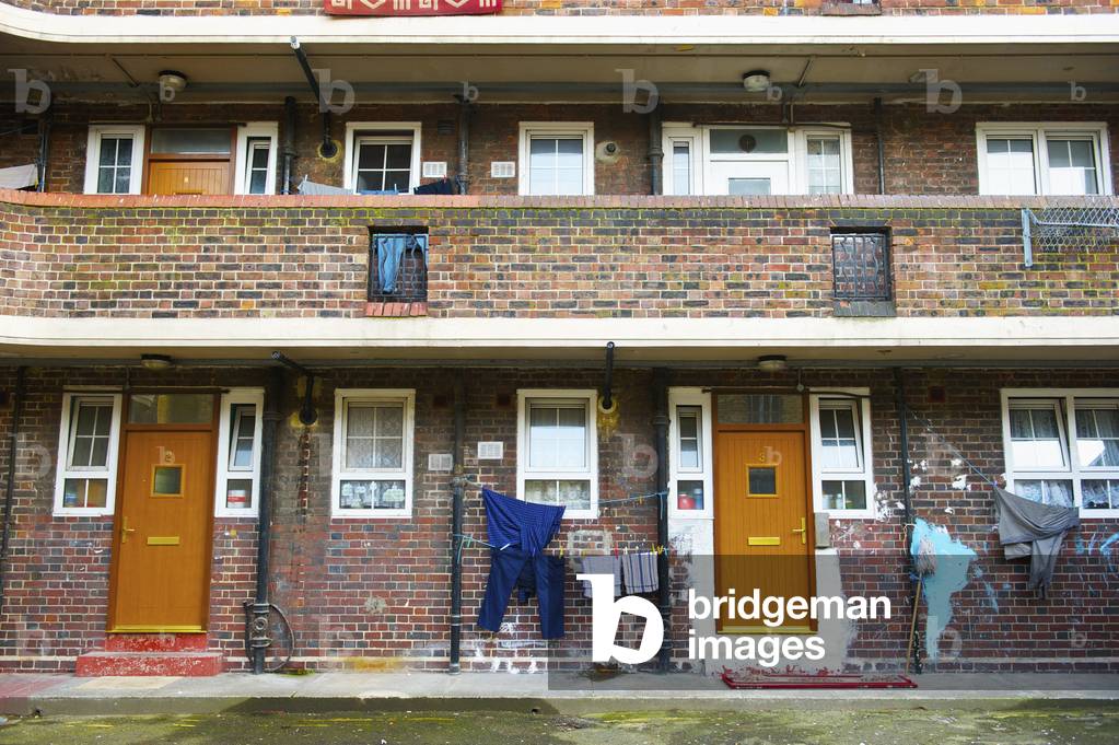 A brick residential building with clothing hanging to dry outside the door, London, England, UK  (photo)