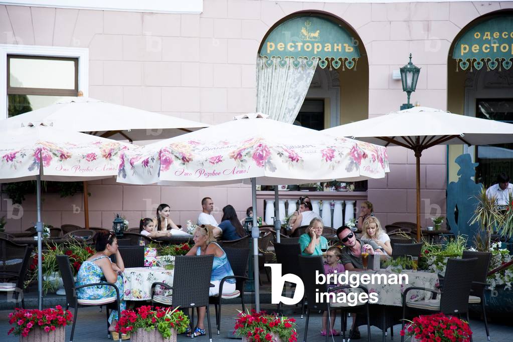 Tourists dining in street cafes outside historic buildings in Odessa city centre, Odessa, Ukraine (photo)