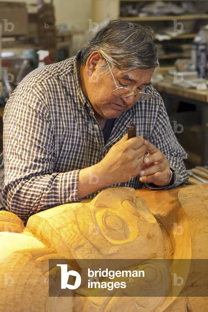 Native Alaskan Artist Carving A Totem Pole At Alaska Indian Arts, Haines, Alaska (photo)