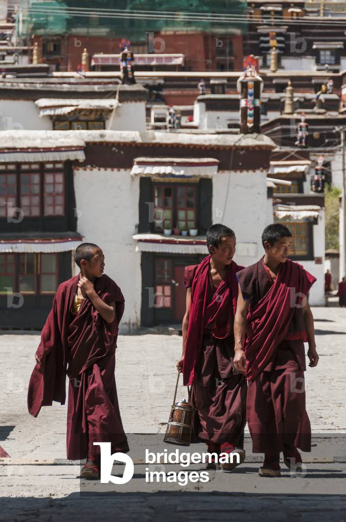 Three young monks walking in Panchen Lamas Tashilhunpo Monastery, Tibetan Friendship Highway, Xigaze, Tibet, China (photo)