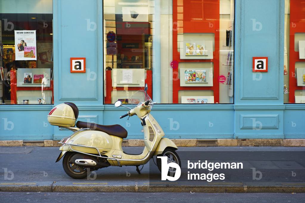 A motorized scooter parked outside a blue building along a street, Canal Saint Martin, Paris, France (photo)