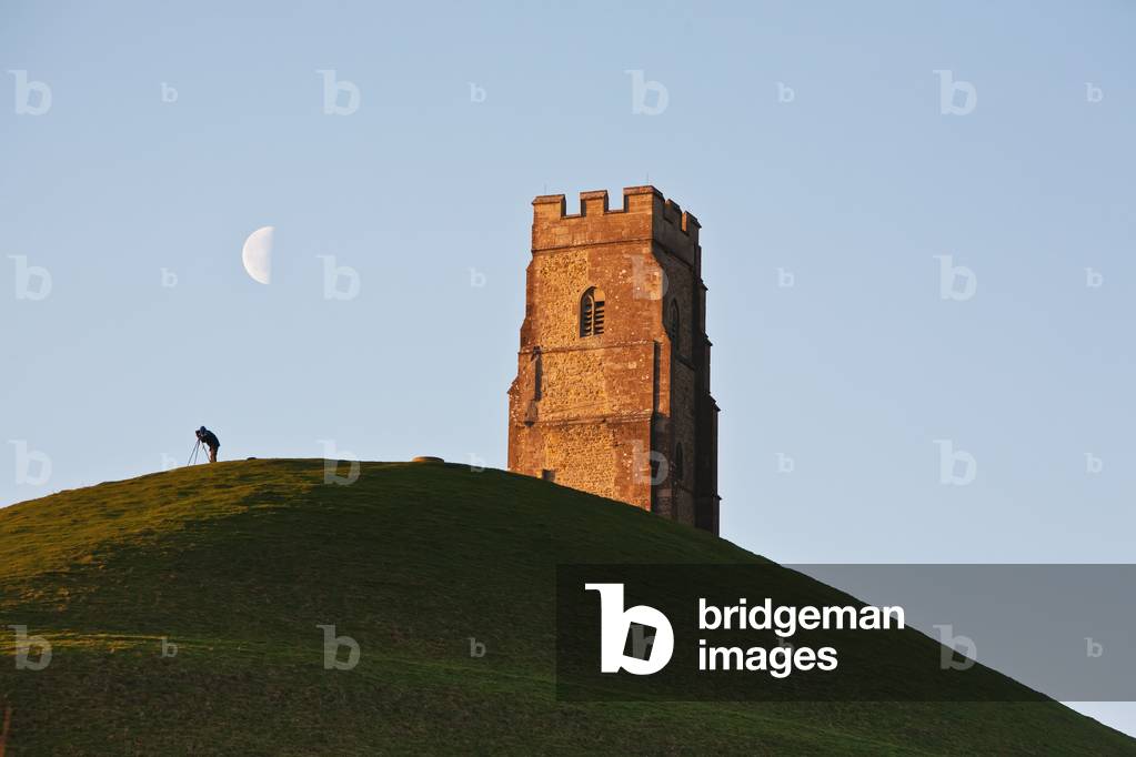 Man Watching Moon with A Telescope Near Tower, Glastonbury,Somerset,England (photo)