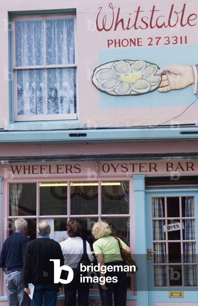 People Looking Into Wheeler's Oyster Bar in Whitstable, Kent, England, UK (photo)