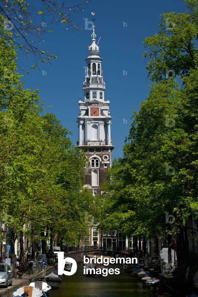 People in small boat going along small canal with spire of the Zuiderkerk church behind, Amsterdam, Holland (photo)
