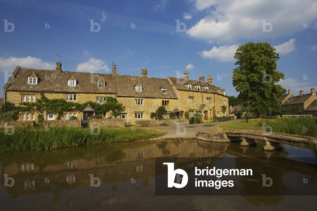 A residential building and it's reflection in water, Lower Slaughter Village, the Cotswolds, Gloucestershire, England, UK  (photo)