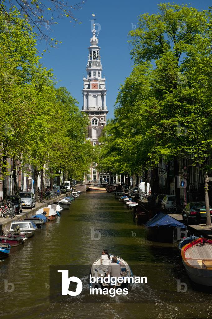 Holland, Couple in boat going along canal with spire of Zuiderkerk church in background, Amsterdam (photo)