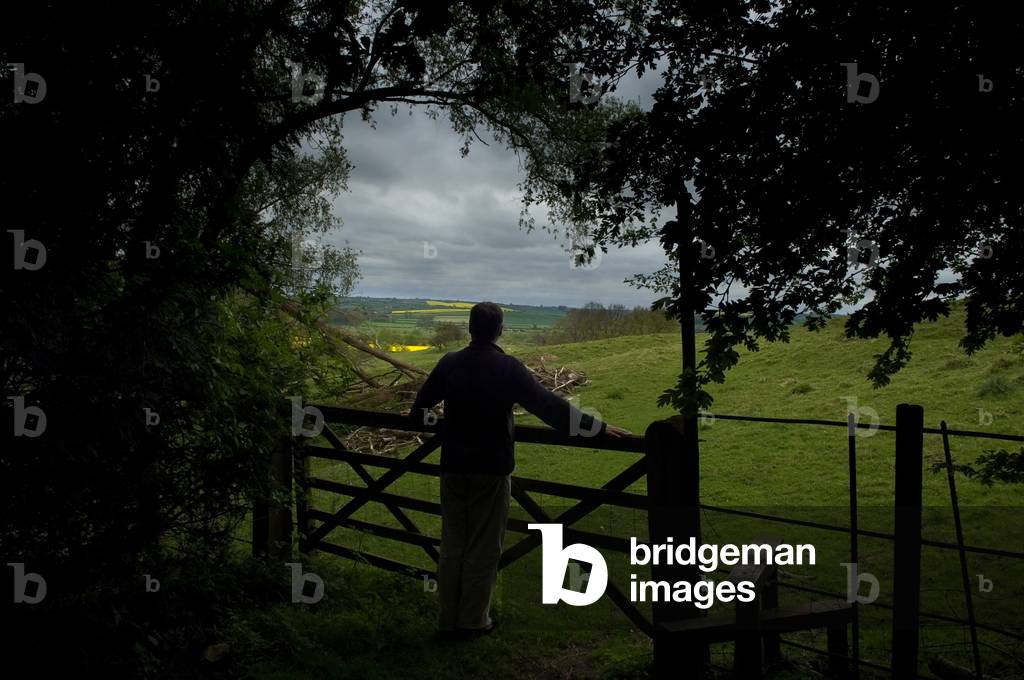 A man stands at a fence viewing the surrounding countryside at Rockingham Castle, Leicestershire, England (photo)