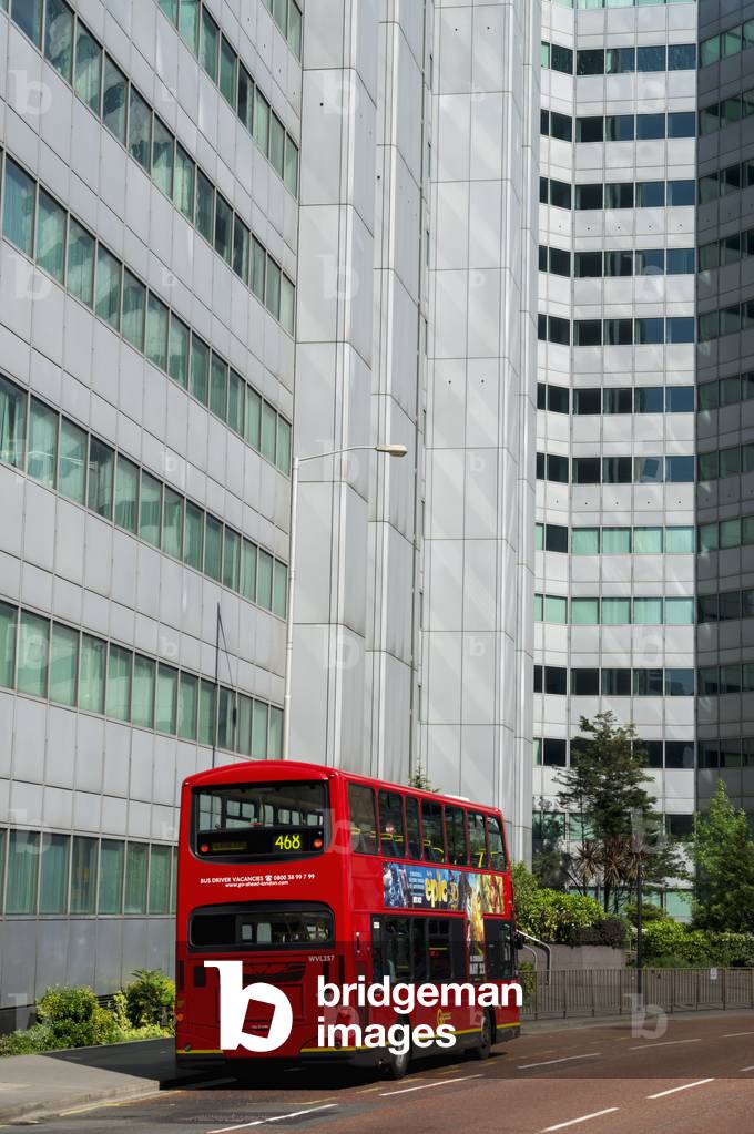 A red double decker bus on the street below an office building, Croydon, London, England, UK  (photo)