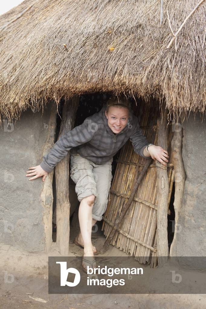 A Young Woman Standing in the Doorway of a Typical Dwelling, Manica, Mozambique, Africa (photo)