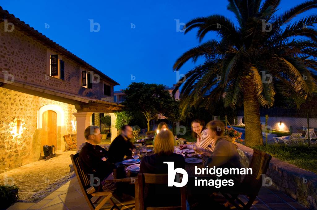People dining outdoor at dusk, Majorca, Spain (photo)