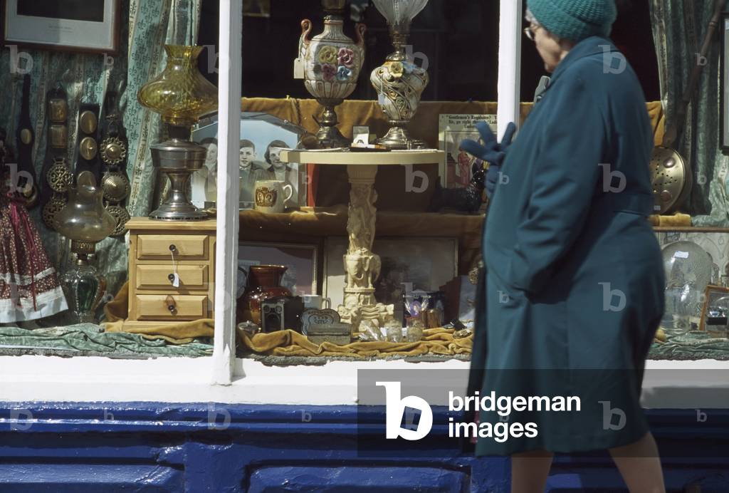 Old Woman Passing Antique Shop Window, Lincolnshire, UK (photo)