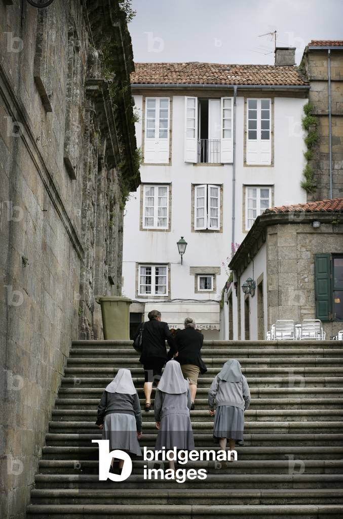 Spain, Galicia, Catholic Nuns Walking Past Cathedral, Santiago De Compostela (photo)
