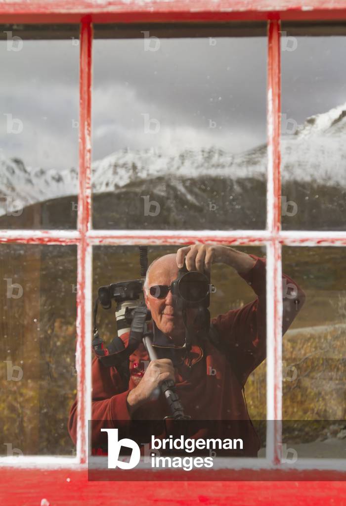 Reflection of photographer in window of Independence Mine building in Hatcher Pass, Southcentral Alaska, USA (photo)