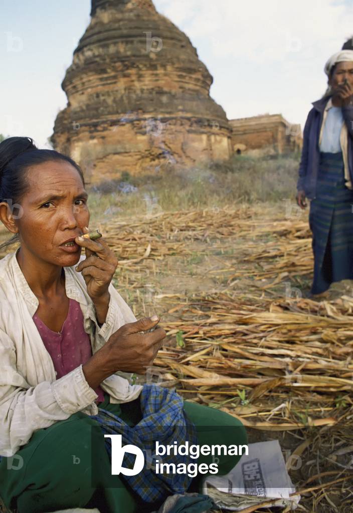 Woman Smoking Cheroots in Field (photo)