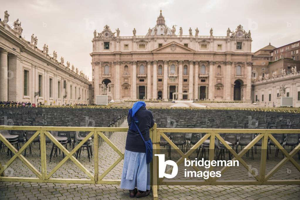 A woman stands at a railing in St. Peter's Square, Rome, Lazio, Italy (photo)