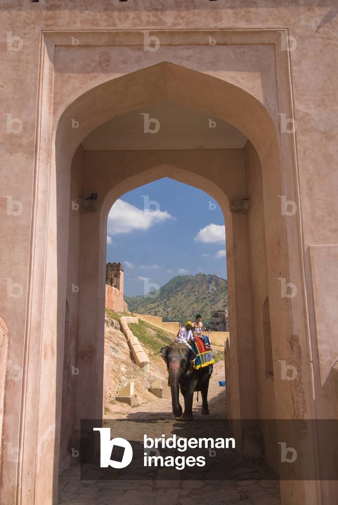 Mahout and Tourist on Elephant Coming Up Path Through Gateway, Amber Fort Near Jaipur, Rajasthan, India (photo)