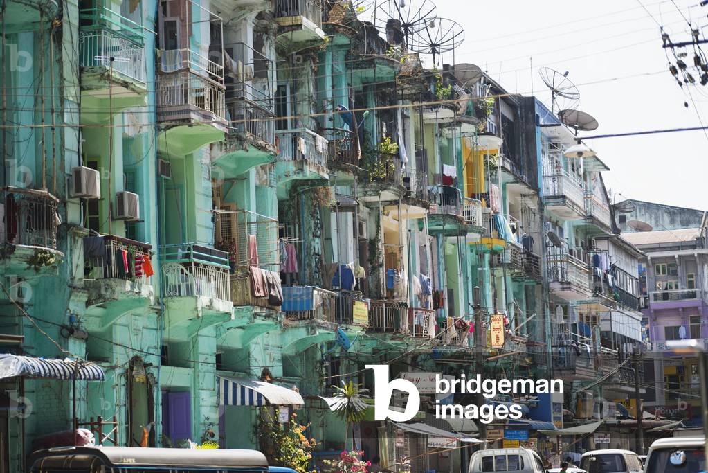 A residential building with balconies, satellite dishes and drying clothes, Rangoon, Burma (photo)