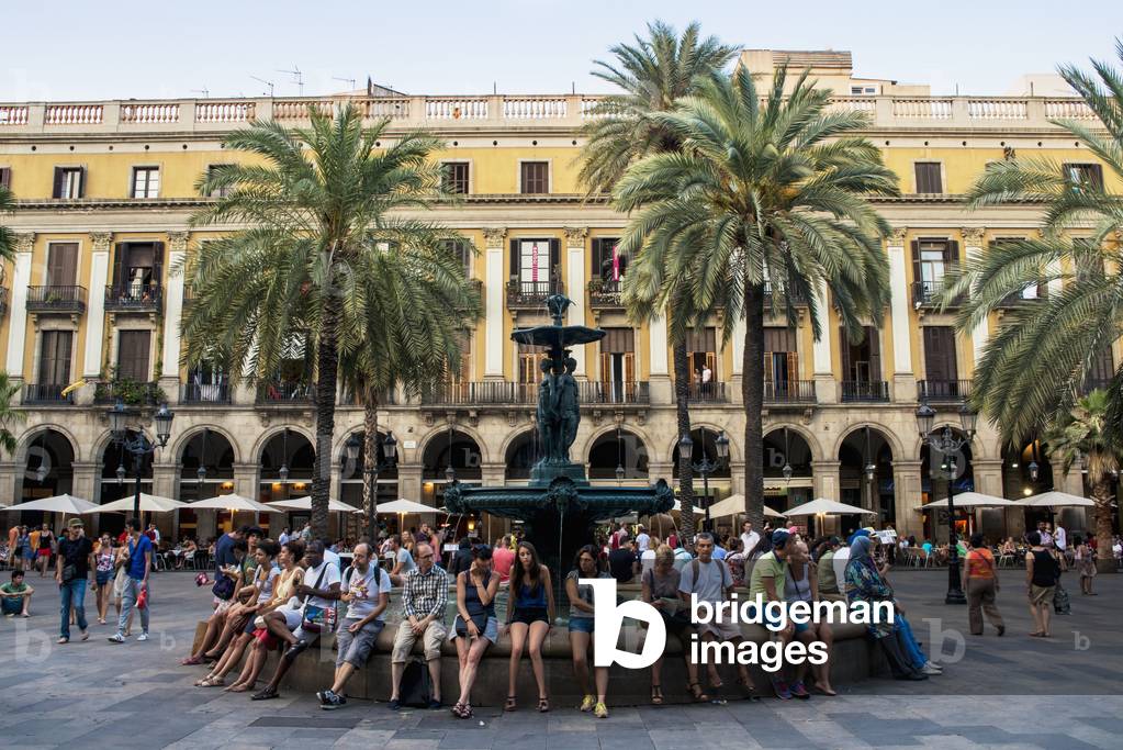 People sitting on the edge of a water fountain at Plaza Real, Barcelona, Catalonia, Spain (photo)