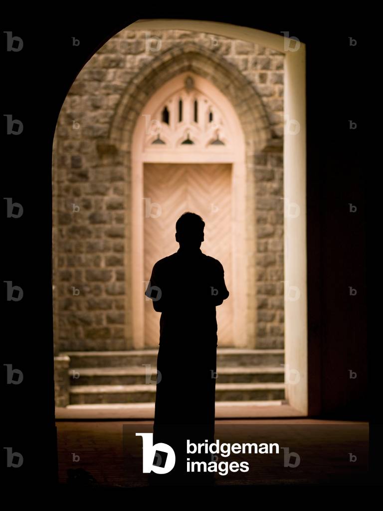 Silhouetted Man Standing in Doorway of a Cathedral, Kerala, India (photo)