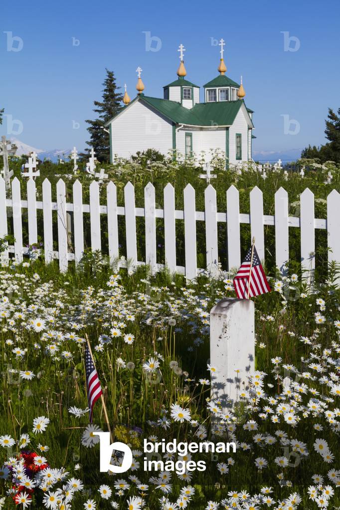 Holy Transfiguration of Our Lord chapel with white picket fence and gravestones marked with American flags, Ninilchik, Kenai Peninsula, Southcentral Alaska, USA (photo)