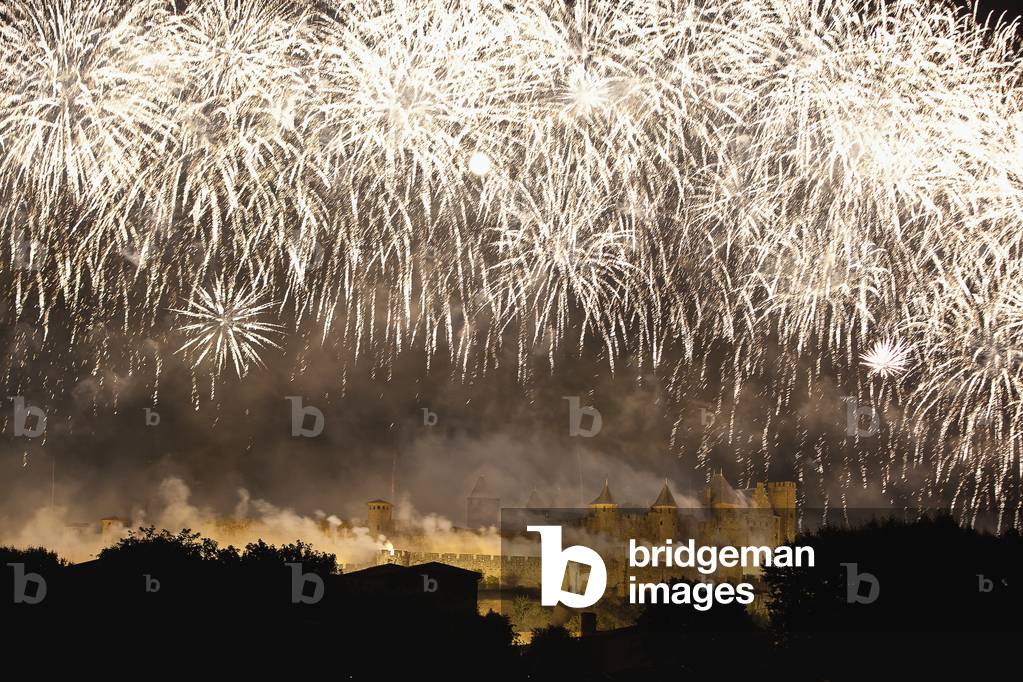 Bastille Day fireworks display with castle and ramparts illuminated at nighttime, Carcassonne, Languedoc-Rousillion, France (photo)