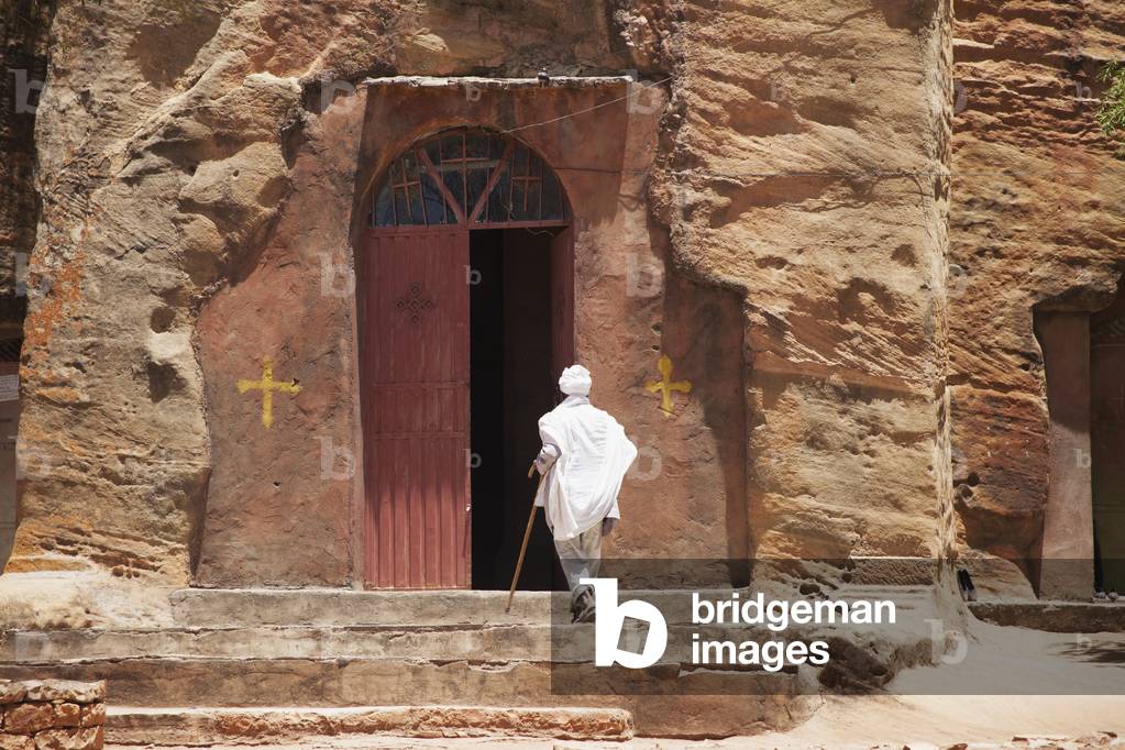 Ethiopian Orthodox christian entering Wukro Chirkos rock-cut church, Wukro, Tigray region, Ethiopia (photo)