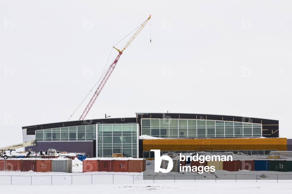 Snow covered shipping containers and a crane surround construction on a new hospital, Barrow, North Slope, Arctic Alaska, USA, Winter (photo)