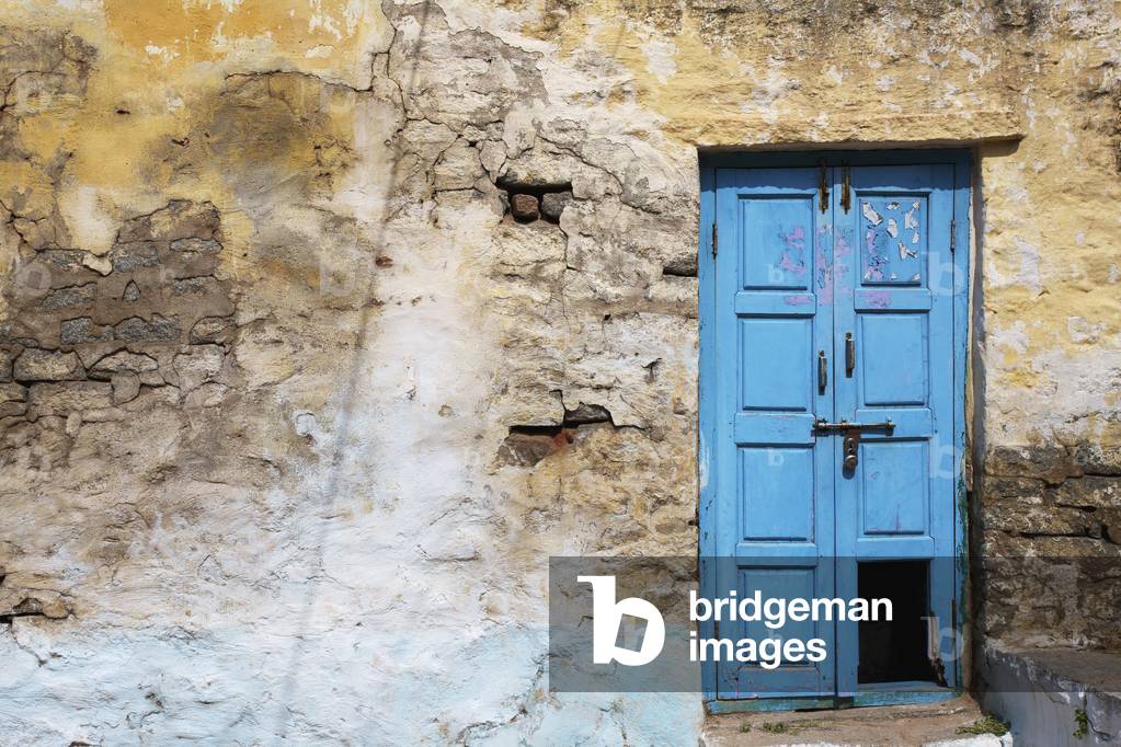 An old, broken blue door along a cracked wall, Hampi, Karnataka, India (photo)