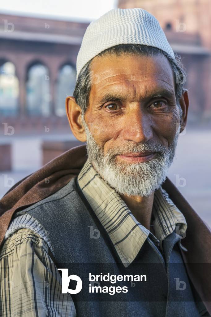 India, Delhi, Portrait of Muslim man with Kashmir at Jama Masjid in background, New Delhi (photo)