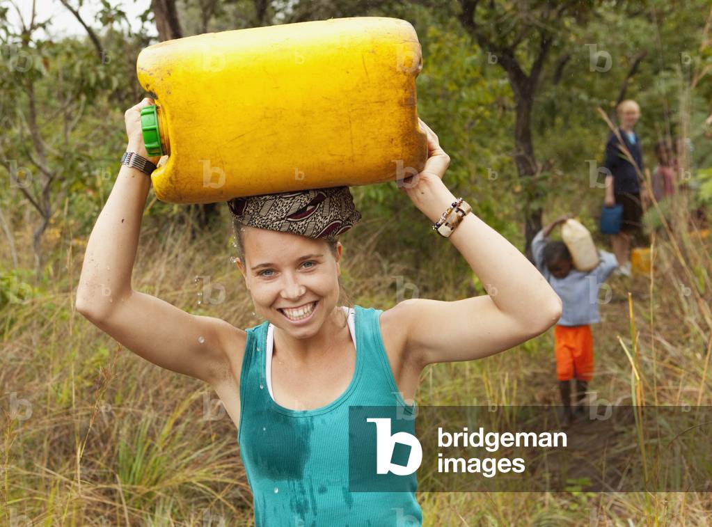 A Young Woman Carries a Water Jug on her Head, Manica, Mozambique, Africa (photo)