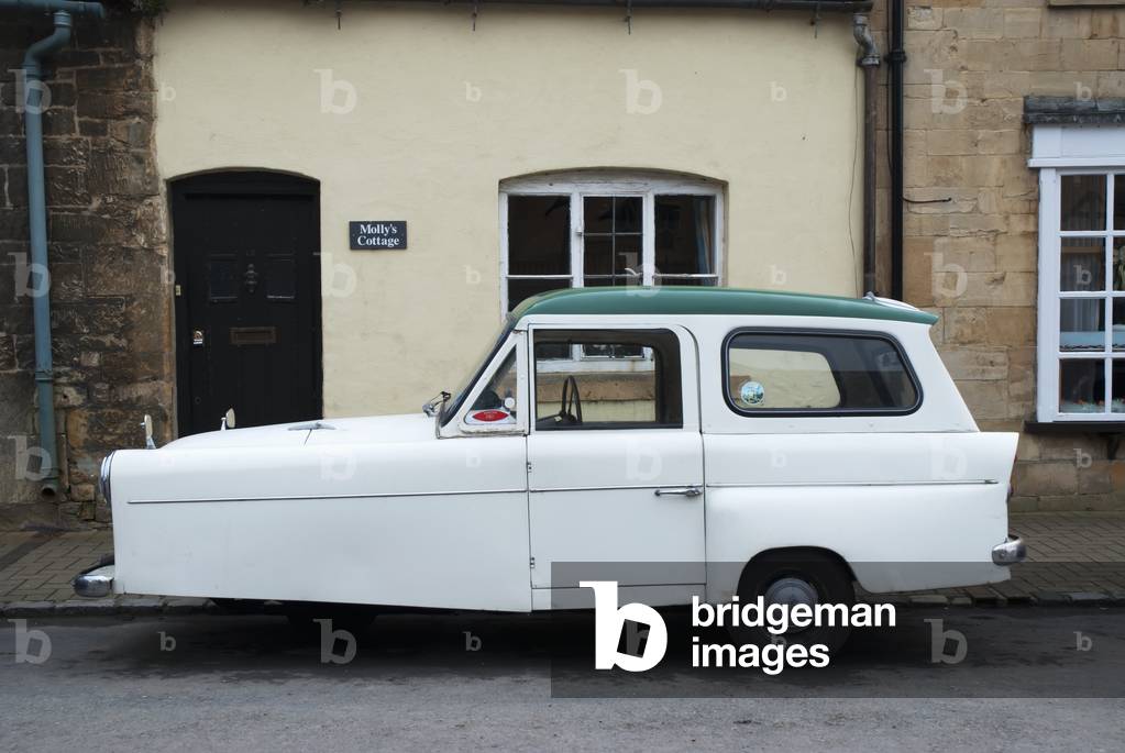 UK, Cotswolds, North Cotswolds, Three wheeler car in front of cottage, Chipping Campden (photo)