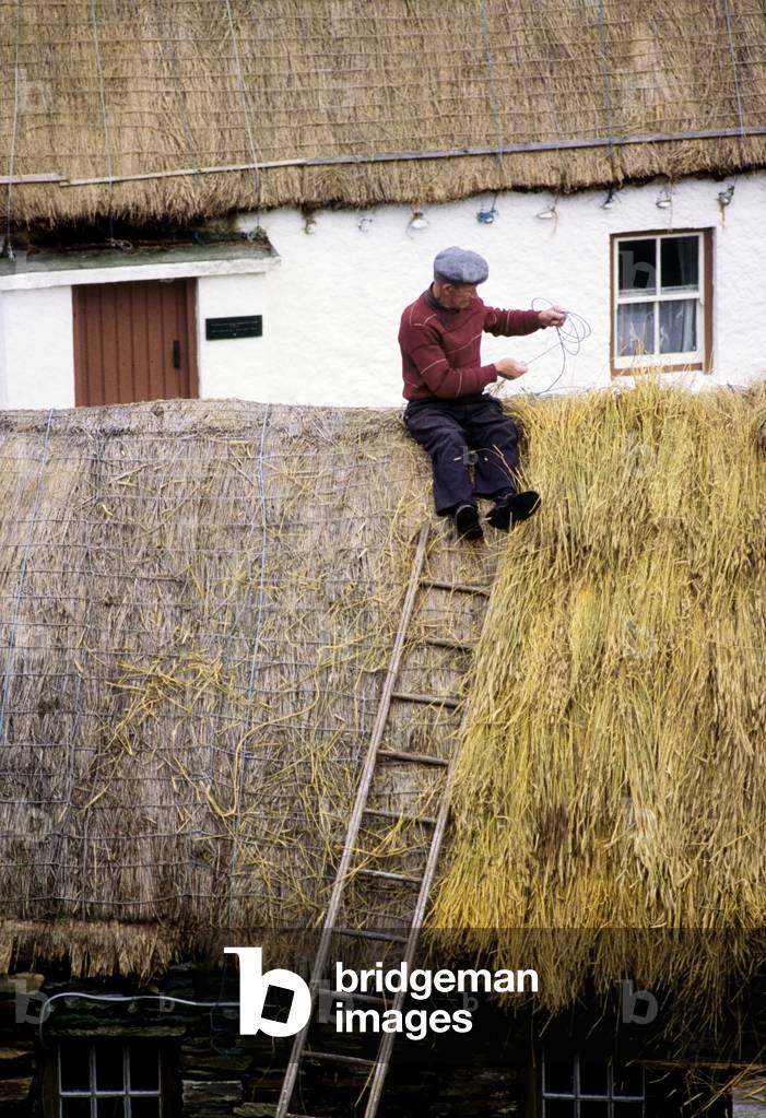 Ireland; Man Thatching A Roof (photo)
