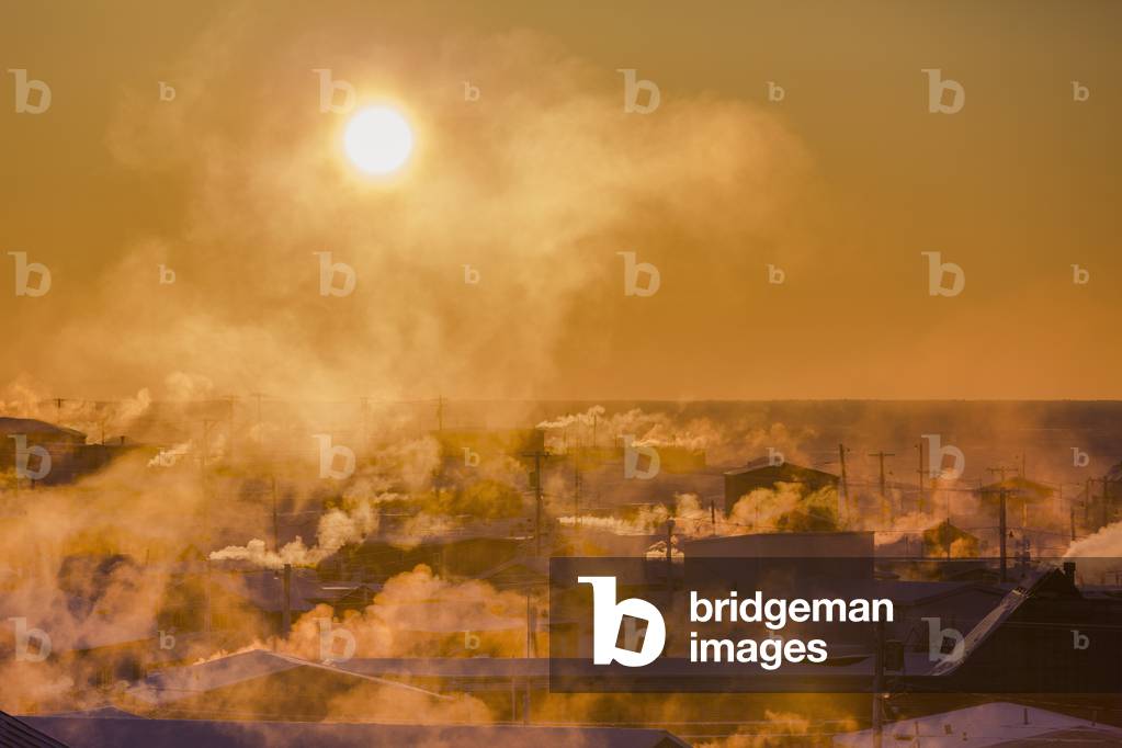 Billowing chimneys of downtown Barrow are silhouetted by the setting sun, Barrow, Arctic Alaska, Winter (photo)