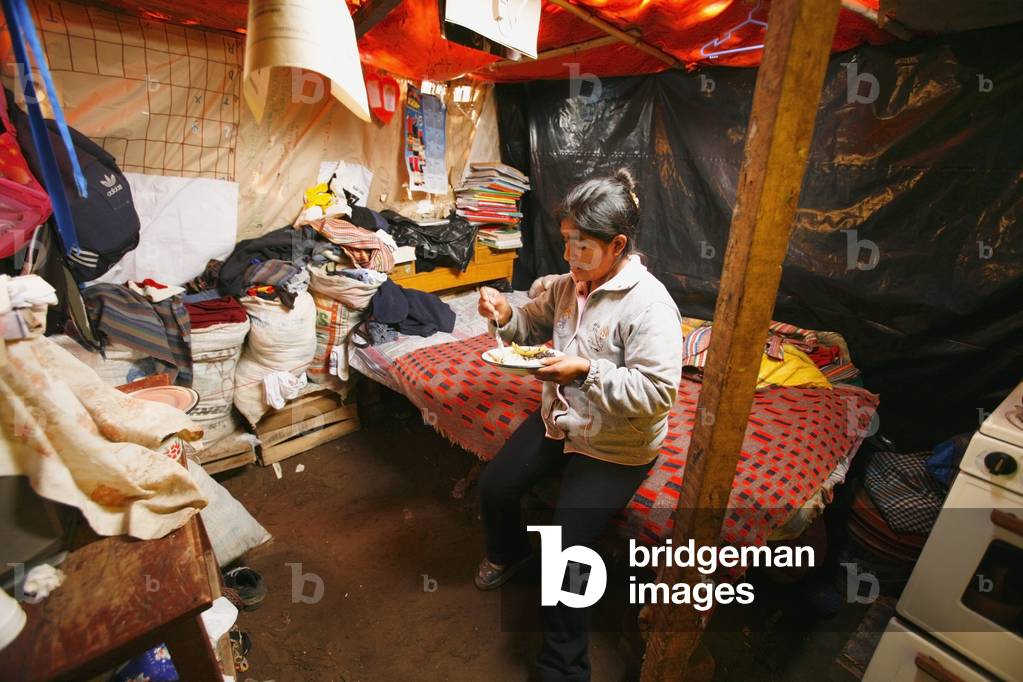 Woman Eating in Poverty Stricken Environment, Lima, Peru (photo)
