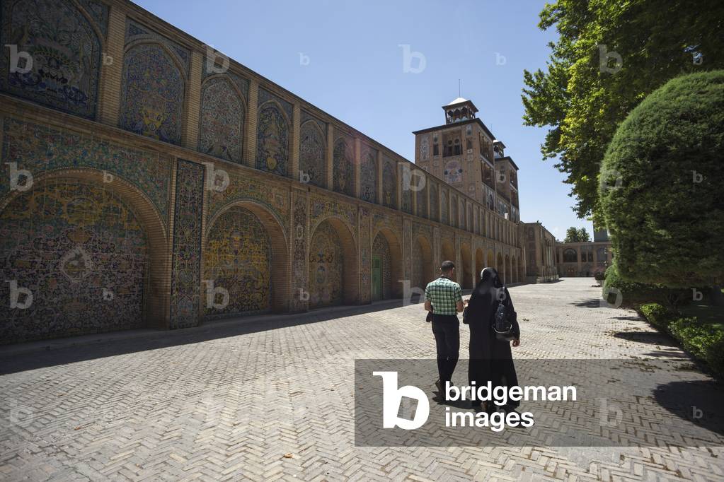 Iranian couple walking towards the Edifice of the Sun (Shams ol Emareh), Golestan Palace, Tehran, Iran (photo)